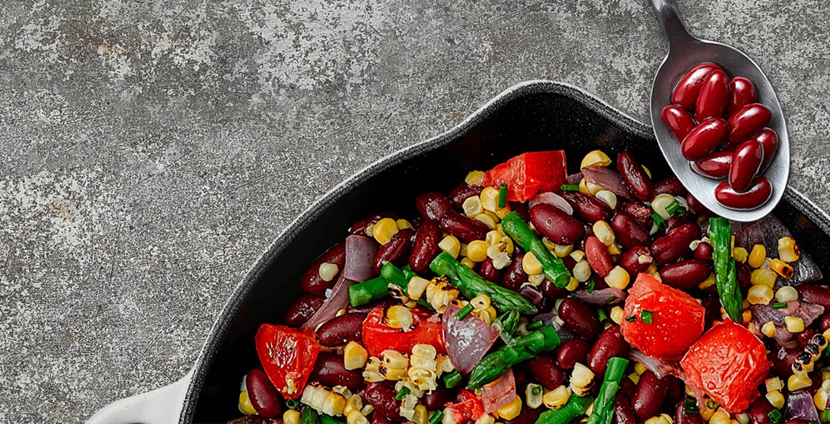 Cast iron pan full of grilled succotash made with Bush’s Best® Kidney Beans